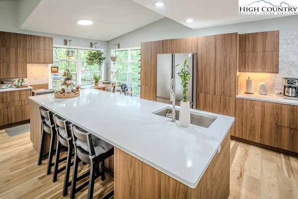 a kitchen with granite countertop a table chairs stove and wooden cabinets