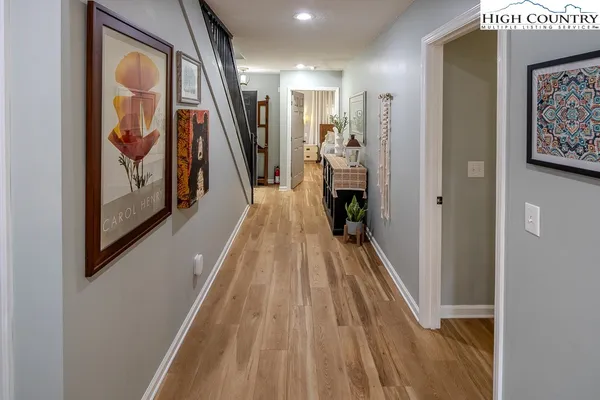 a view of a hallway with wooden floor and stairs