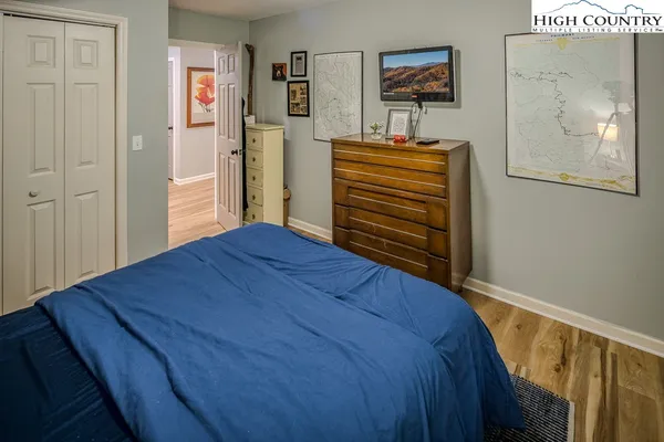 a bedroom with a bed and painting on the wall