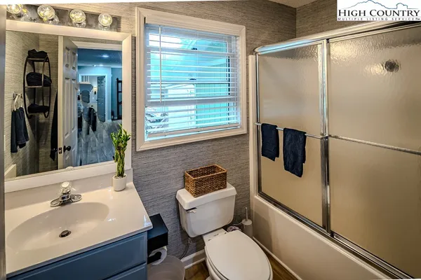 a bathroom with a sink mirror toilet and shower