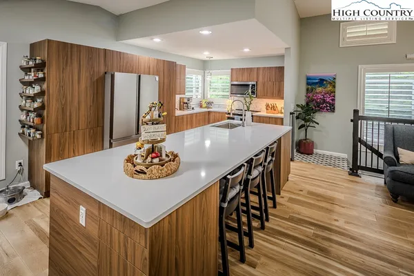 a kitchen with stainless steel appliances granite countertop a table chairs a refrigerator and a stove