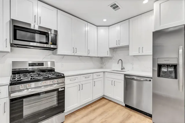 a kitchen with stainless steel appliances granite countertop a stove microwave and cabinets