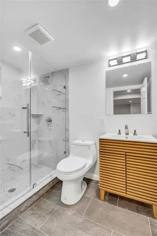 a bathroom with a sink toilet a mirror and shower
