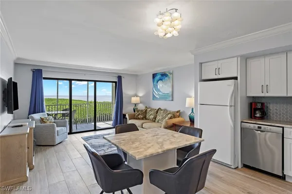 a view of a dining room with furniture a chandelier and wooden floor