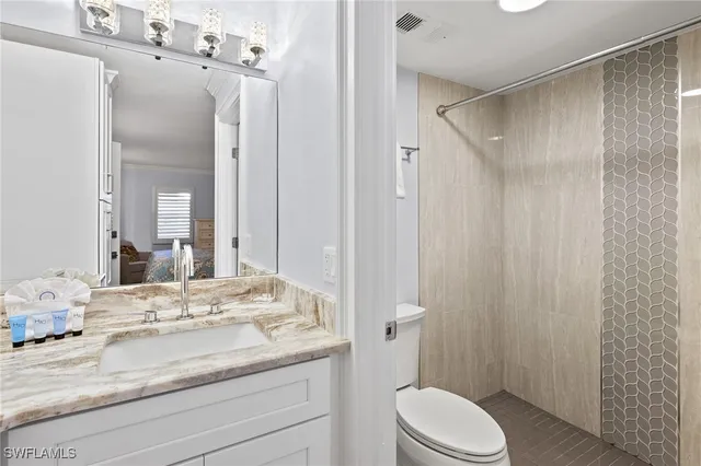 a bathroom with a granite countertop sink toilet and shower