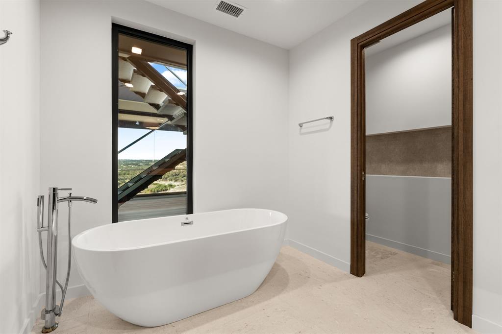 2714 Lakehurst Road Spicewood, TX 78669 - Photo 27 of 37 Bathroom featuring baseboards and a freestanding tub