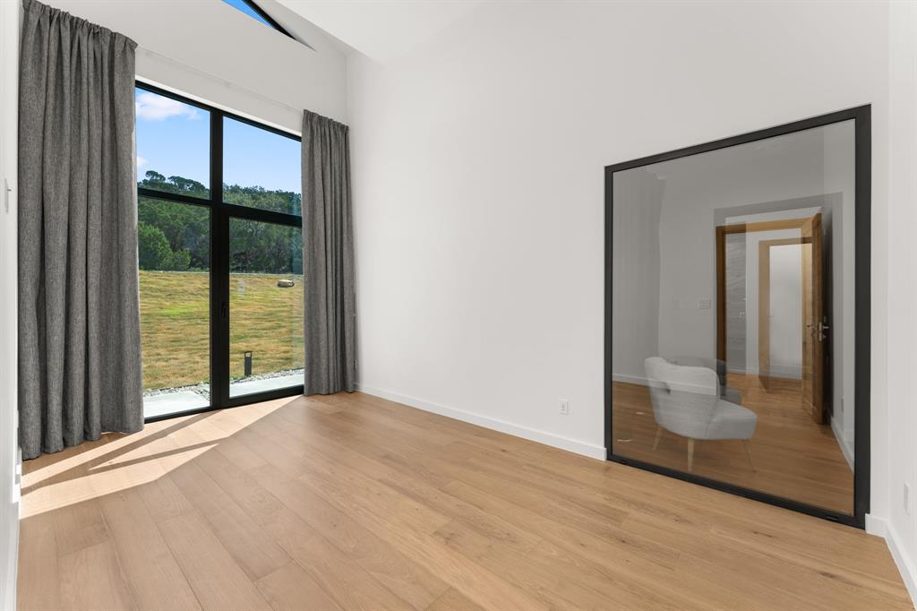 2714 Lakehurst Road Spicewood, TX 78669 - Photo 30 of 37 Unfurnished bedroom featuring light wood-style flooring and baseboards