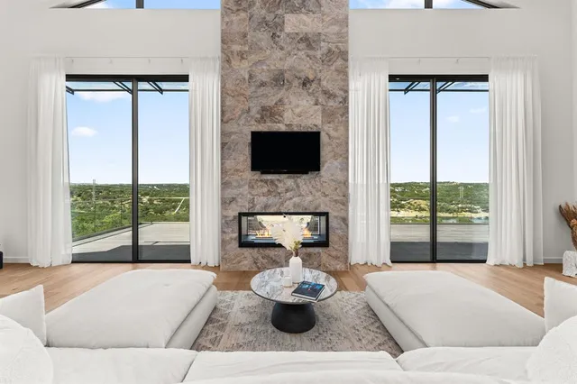 a living room with furniture kitchen view and a large window