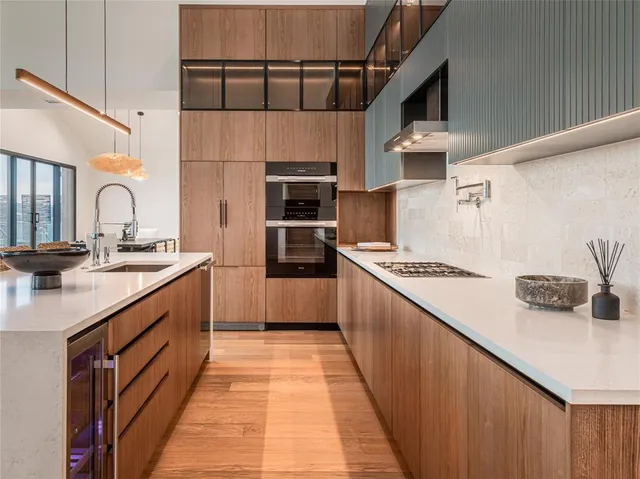 a kitchen with stainless steel appliances kitchen island granite countertop a table chairs sink and cabinets
