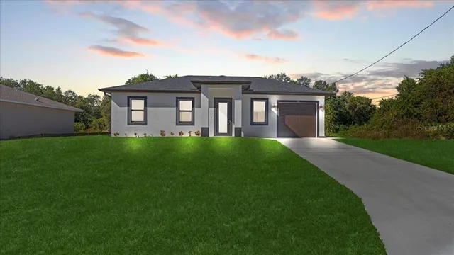 a front view of a house with a yard and garage