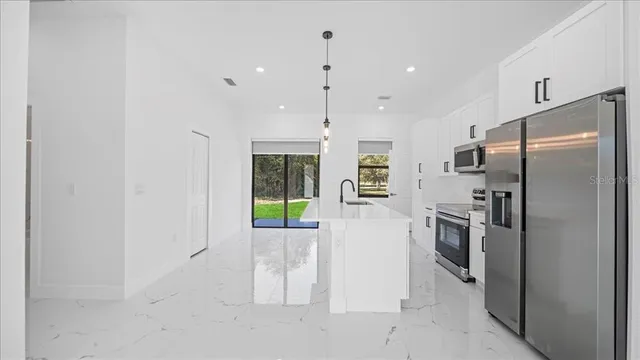 a kitchen with stainless steel appliances a refrigerator sink and stove