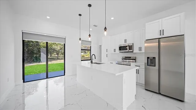 a kitchen with stainless steel appliances a refrigerator sink and cabinets