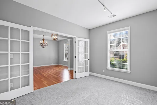 a view of an empty room with a window and cabinet area