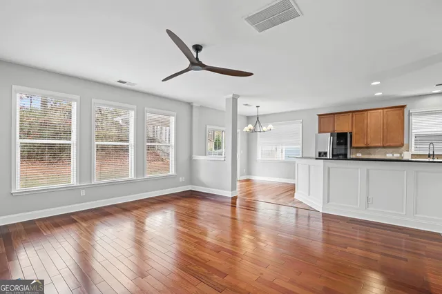 a kitchen with stainless steel appliances granite countertop wooden cabinets a sink and dishwasher a stove with wooden floors