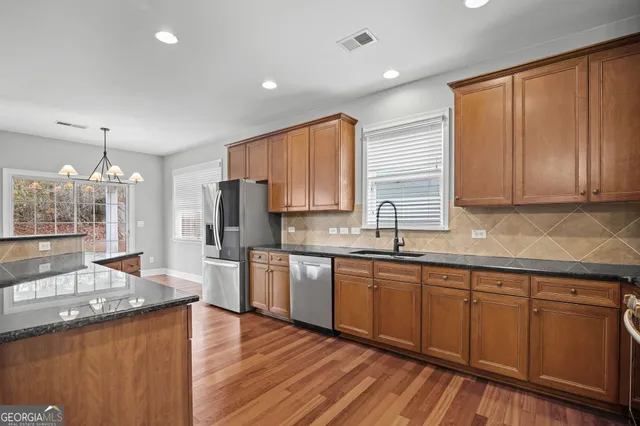 a kitchen with granite countertop a sink and a wooden floors