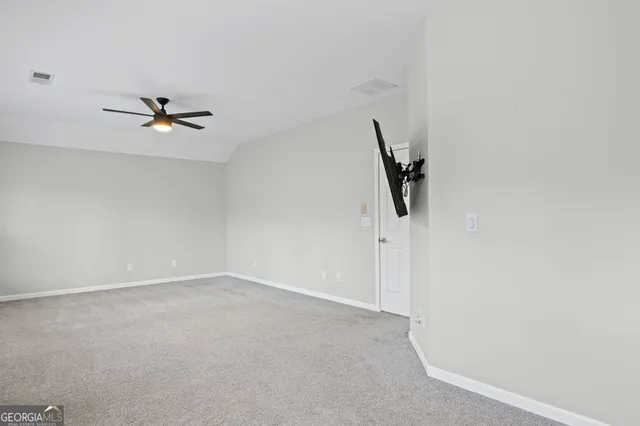 a view of a livingroom with an empty space and a ceiling fan