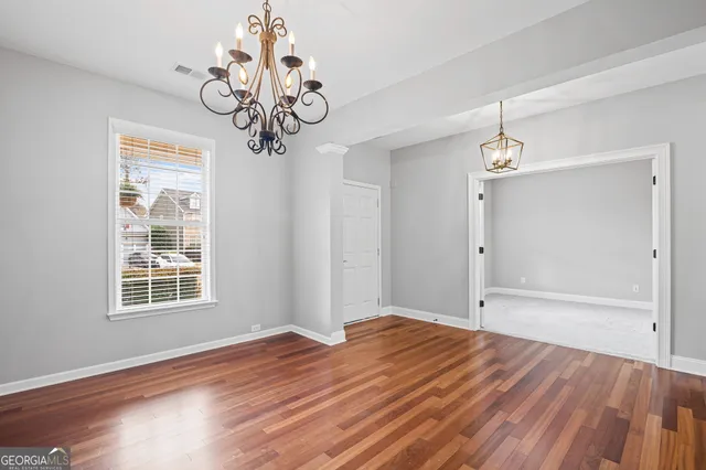 a view of a big room with wooden floor and chandelier