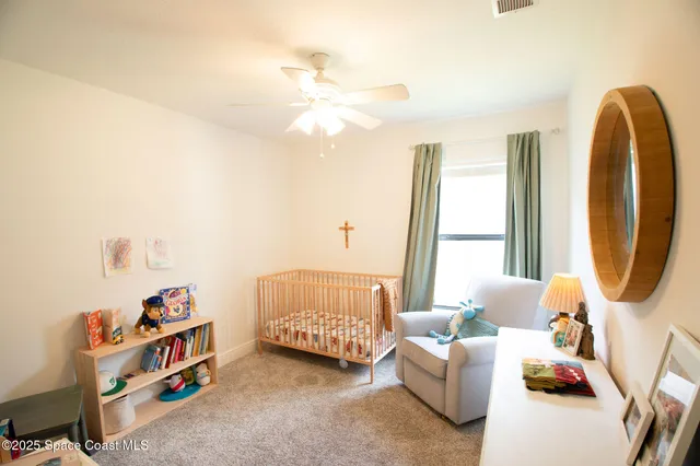 a living room with furniture and a baby crib