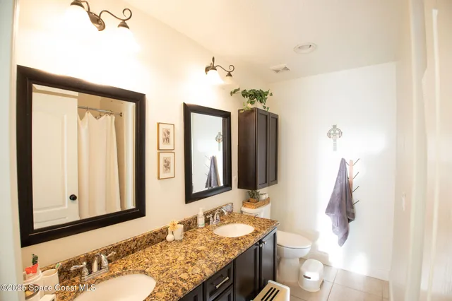 a bathroom with double vanity and a mirror