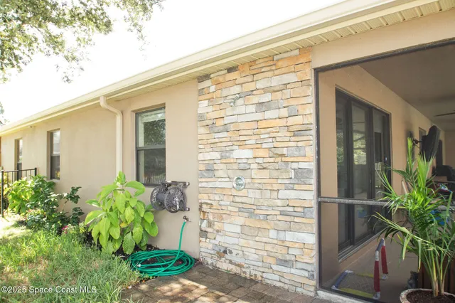 a front view of a house with a yard and potted plants