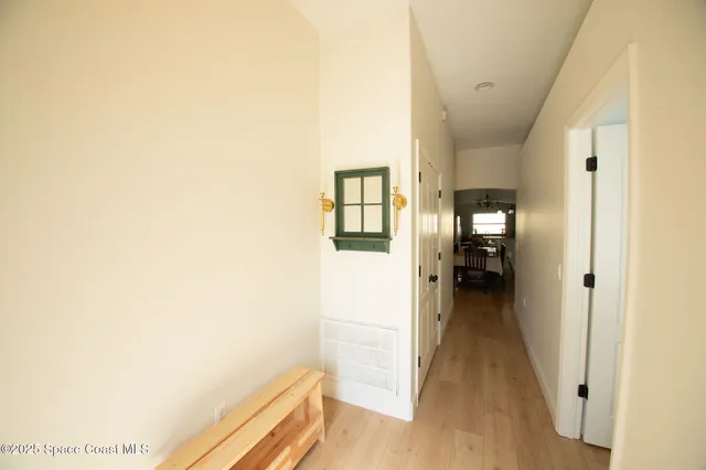 a view of a hallway with wooden floor and a living room