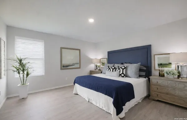 a bedroom with a large bed and a potted plant