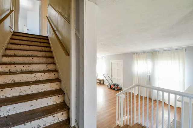a view of a hallway with wooden floor and windows