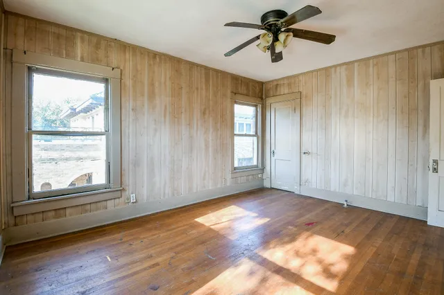 a view of a livingroom with a chandelier fan and windows