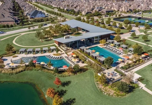 an aerial view of residential houses with outdoor space and swimming pool