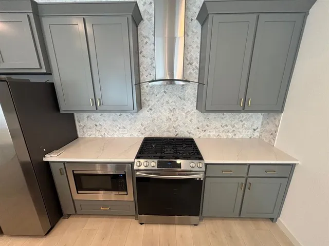 a kitchen with granite countertop white cabinets and stainless steel appliances