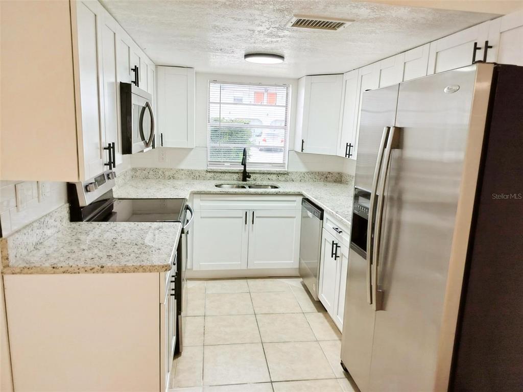 9901 Grace Drive Port Richey, FL 34668 - Photo 4 of 35 a kitchen with a refrigerator sink and stove