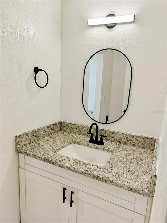 9901 Grace Drive Port Richey, FL 34668 - Photo 7 of 35 a bathroom with a granite countertop sink and a mirror
