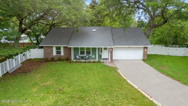 a aerial view of a house next to a big yard and large trees