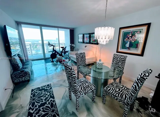 a living room with furniture a flat screen tv and kitchen view