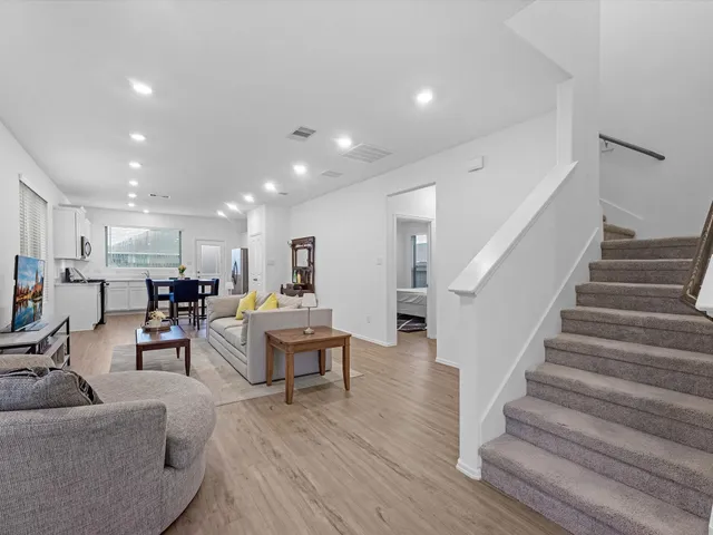 a living room with furniture and a view of kitchen