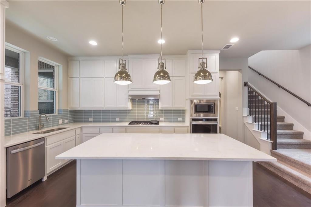 a kitchen with stainless steel appliances kitchen island a sink a stove and a refrigerator