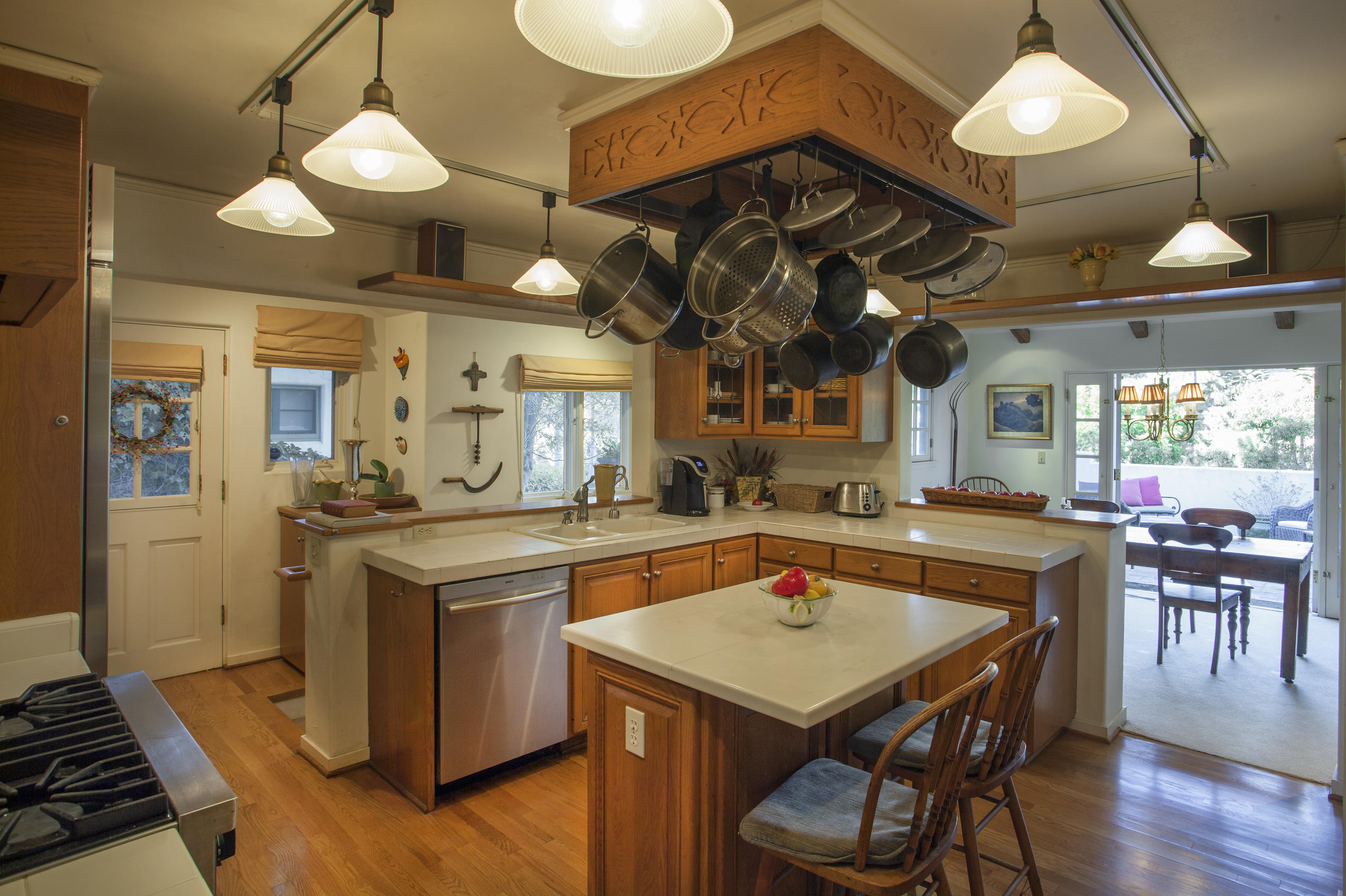2141 Mission Ridge Road Santa Barbara, CA 93103 - Photo 7 of 18 a kitchen with a stove a kitchen island a dining table and chairs with wooden floor