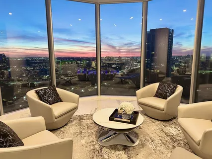 a living room with furniture and a floor to ceiling window