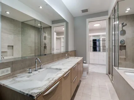 a bathroom with a granite countertop sink a mirror and a bathtub
