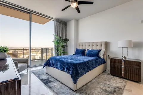 a living room with a bed furniture and a floor to ceiling window