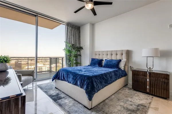 a living room with a bed furniture and a floor to ceiling window