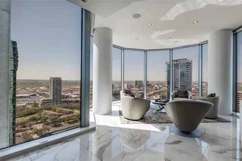 a living room with furniture a window and a potted plant