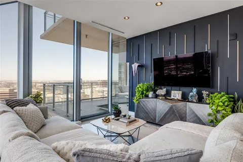 a living room with furniture kitchen view and a large window