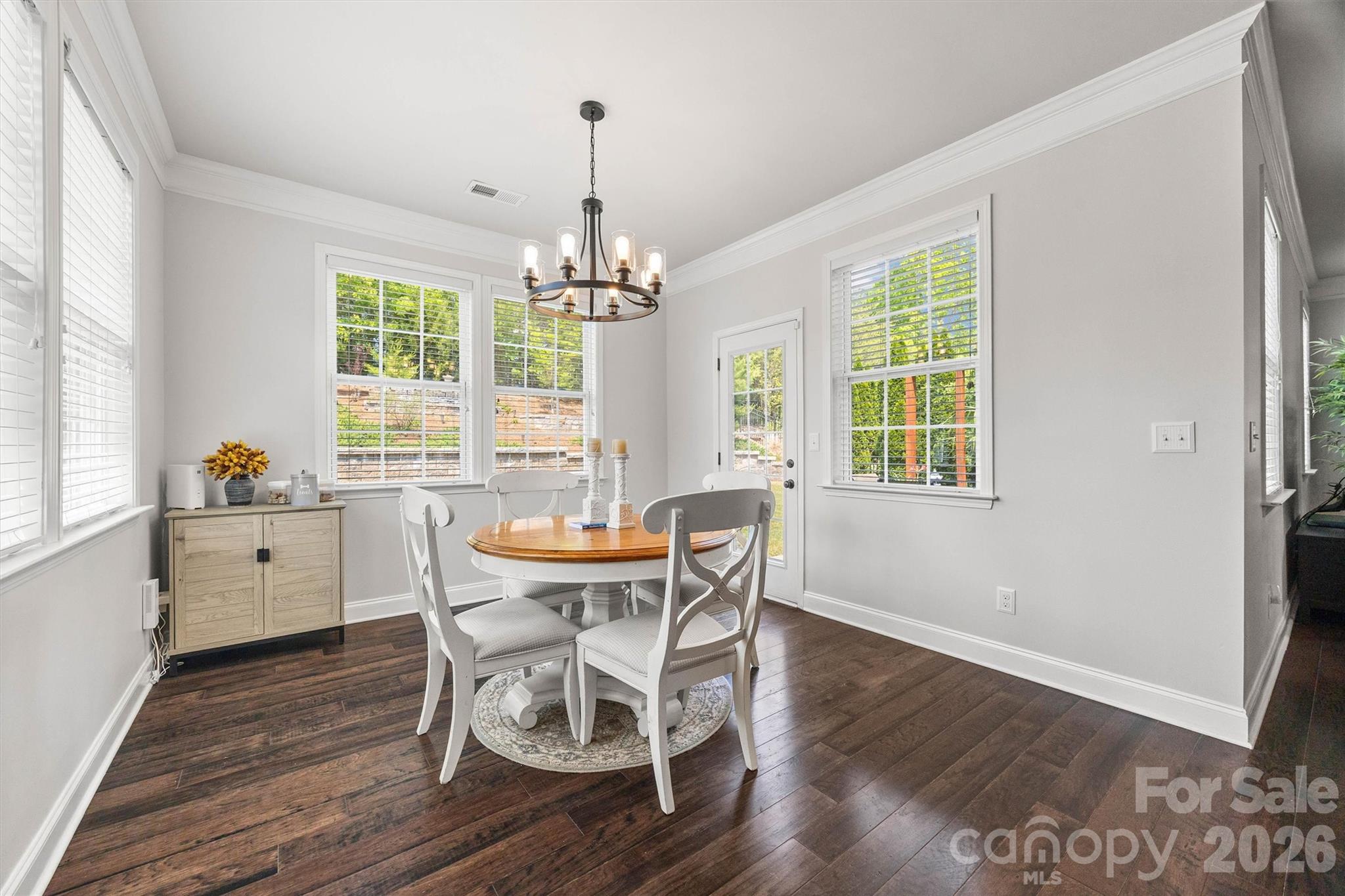 299 Annatto Way Tega Cay, SC 29708 - Photo 14 of 46 a dining room with wooden floor a chandelier a wooden table and chairs