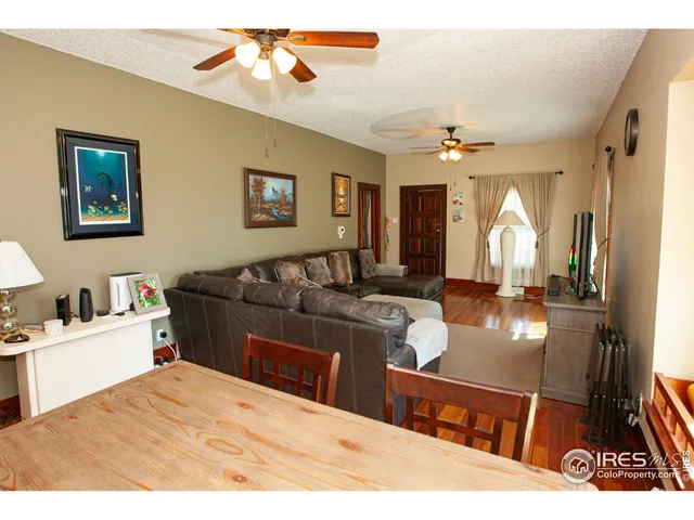 a living room with stainless steel appliances kitchen island granite countertop furniture a rug and a chandelier