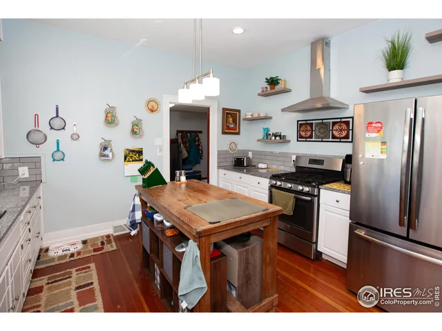 a kitchen with stainless steel appliances granite countertop a refrigerator a stove and a sink