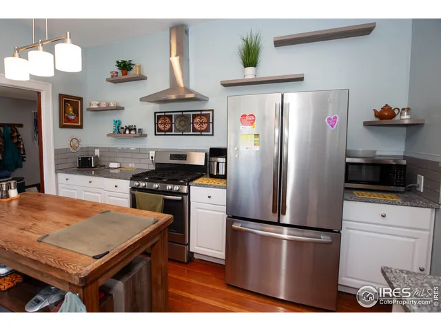 a kitchen with stainless steel appliances a refrigerator a stove a sink and a refrigerator
