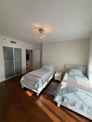 a bedroom with double bed and a chandelier