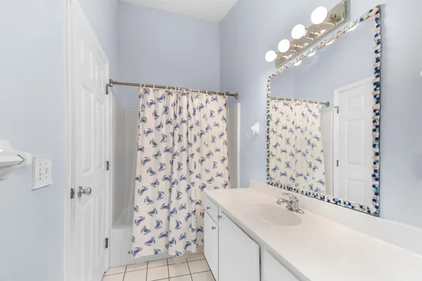 a bathroom with a sink mirror and a shower
