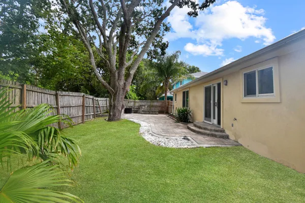 a view of backyard with table and chairs and wooden fence